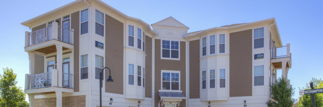 Exterior of multi-level apartment building with attached garage.